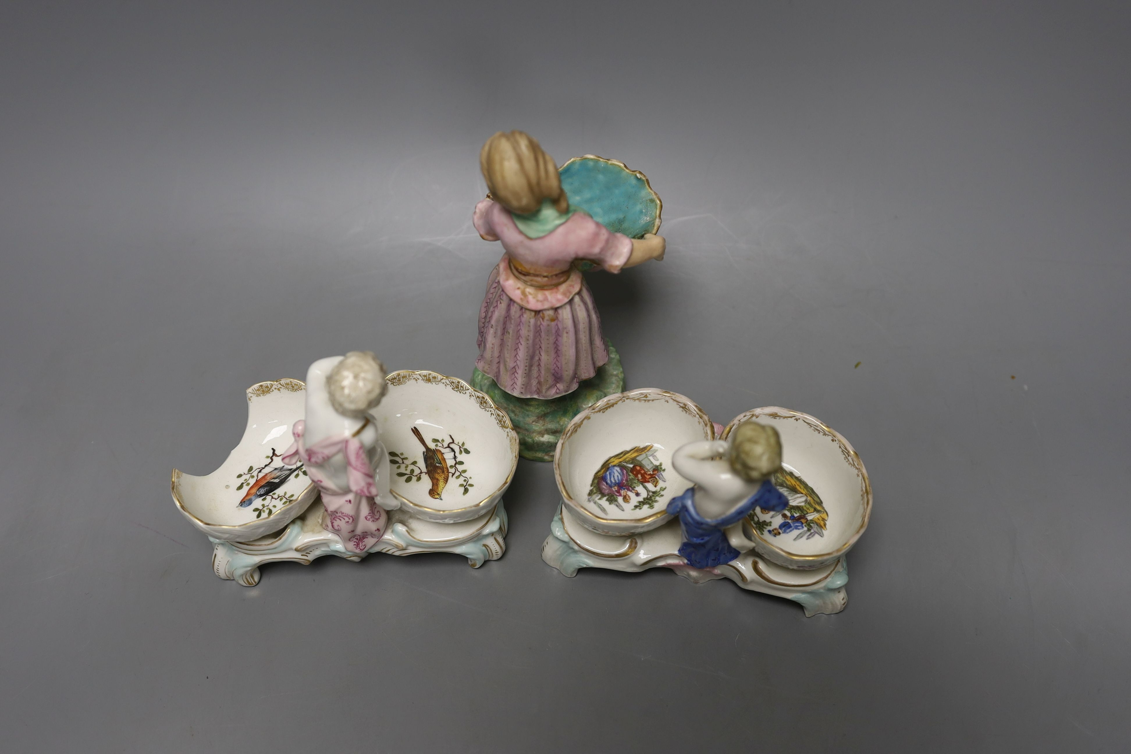 Two 19th century German porcelain putti salts and a Sampson Hancock, Derby figurine holding a shell (3) - tallest 17.5cm